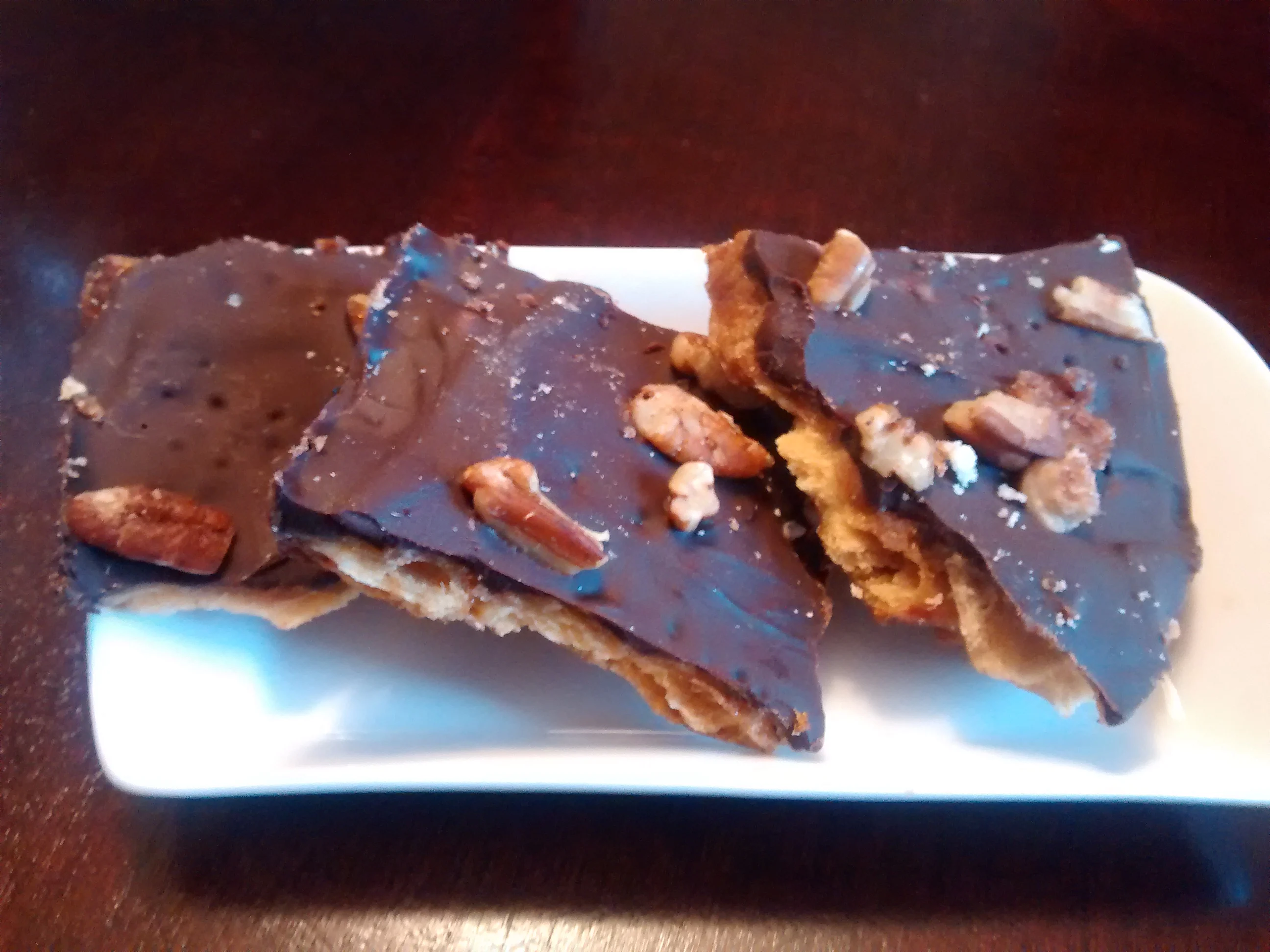 Saltine Toffee Bars smothered in chocolate on white ceramic dish