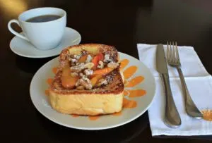 French Toast on colorful plate with a cup of coffee and cloth napkin