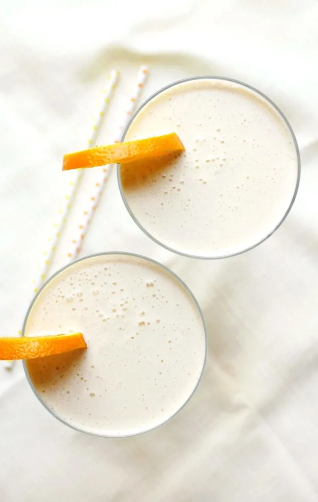 Two glasses of Orange Julius Cocktails with orange slices on top