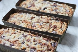 Three pans with cherry coffee cake lined up