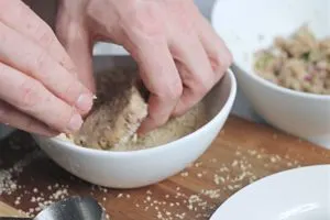 rolling fish cakes in panko crumbs 