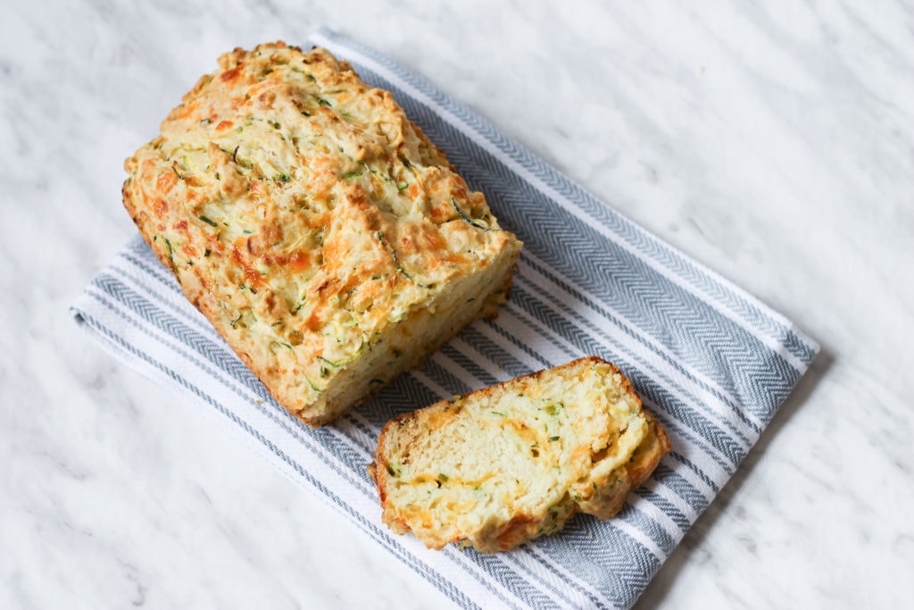 Zucchini Loaf sliced on grey tea towel 