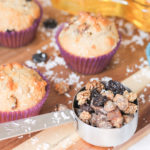 Mixed Berry Muffins with shredded coconut and dried fruit in measuring cup