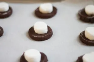 Dough for Chocolate cookies with marshmallow halves on top on baking sheet