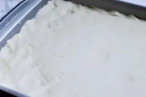 Baking sheet with rolled cookie dough pressed into corners