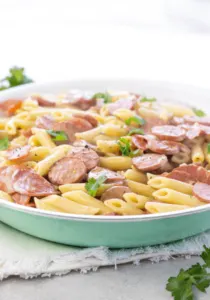 Large white bowl of pasta with sausage and pepperoni