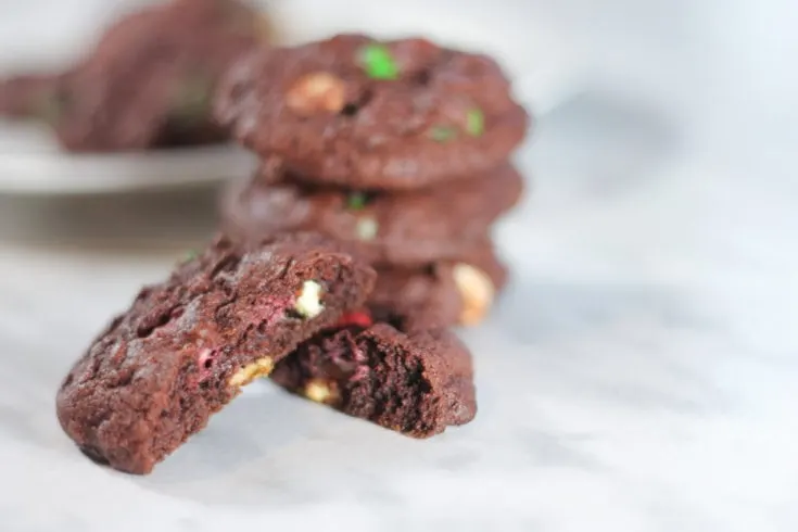 red velvet cookies stacked on marble countertop.