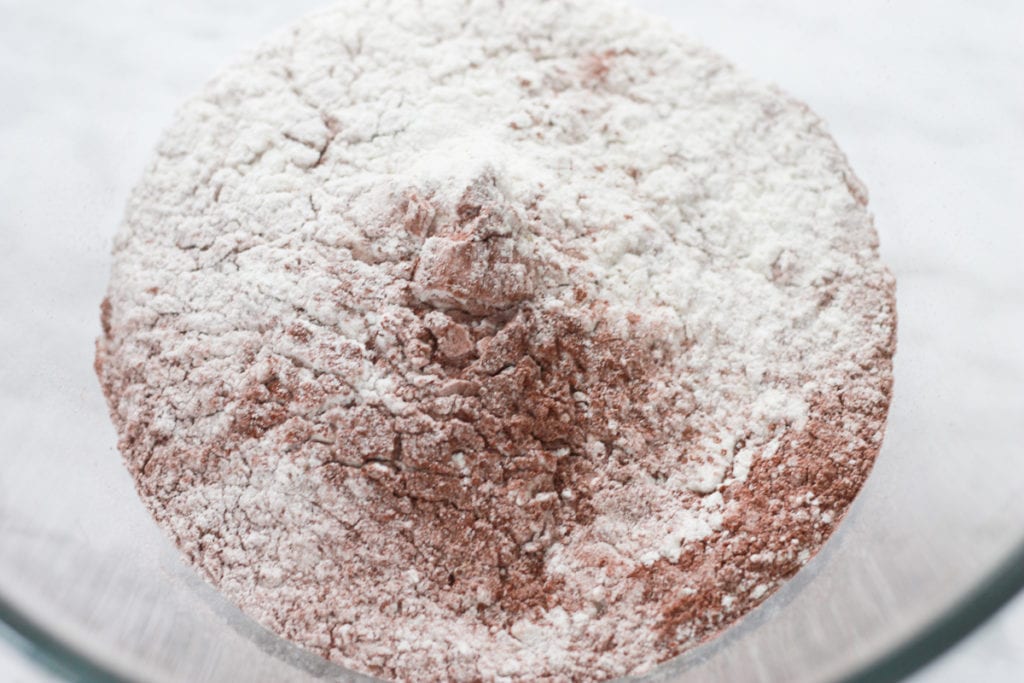 Clear glass bowl with dry ingredients for cookies.