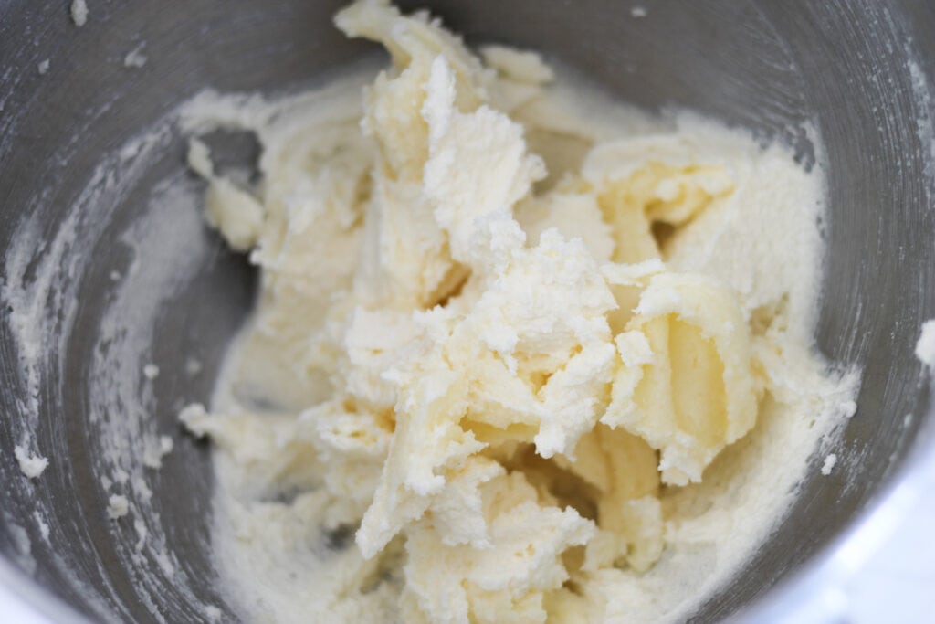 Creamed butter and sugar in stainless steel mixing bowl.