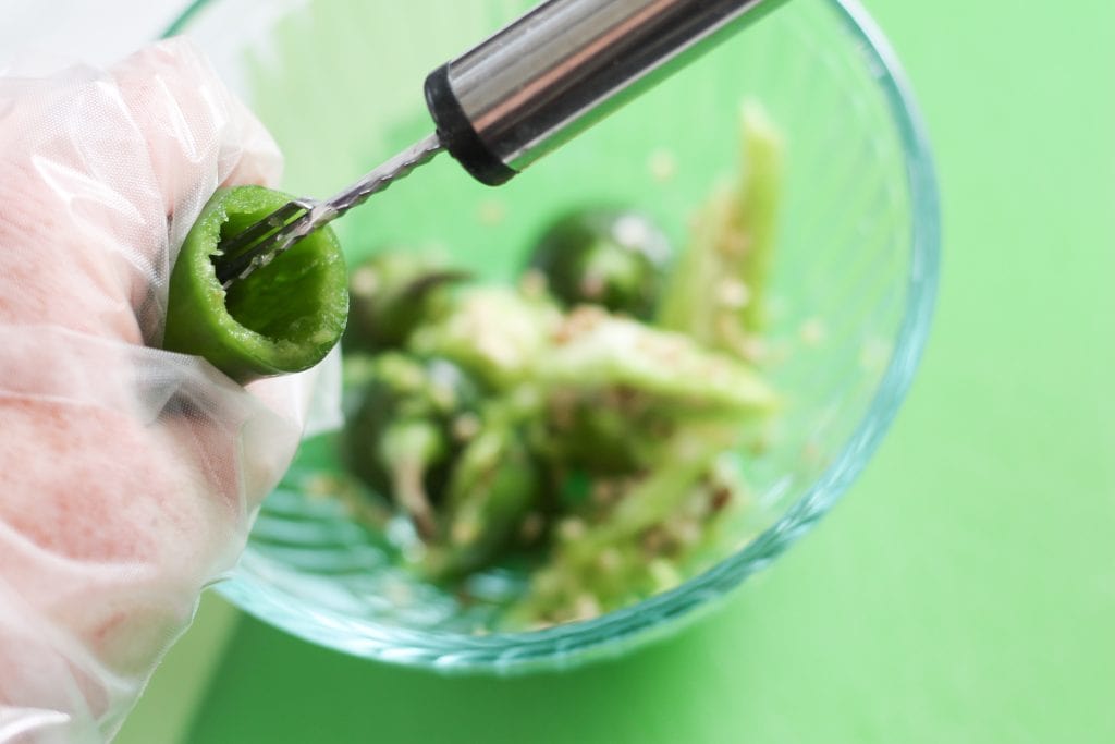 Coring tool being used to remove seeds from jalapeno.