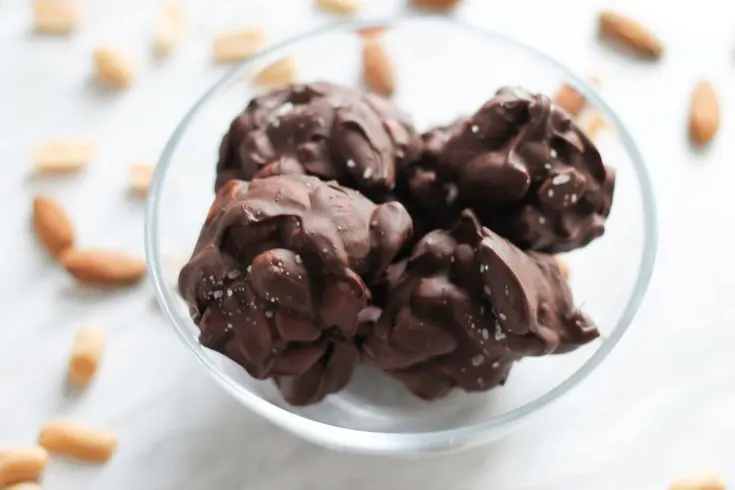 Chocolate nut clusters in glass bowl on countertop.