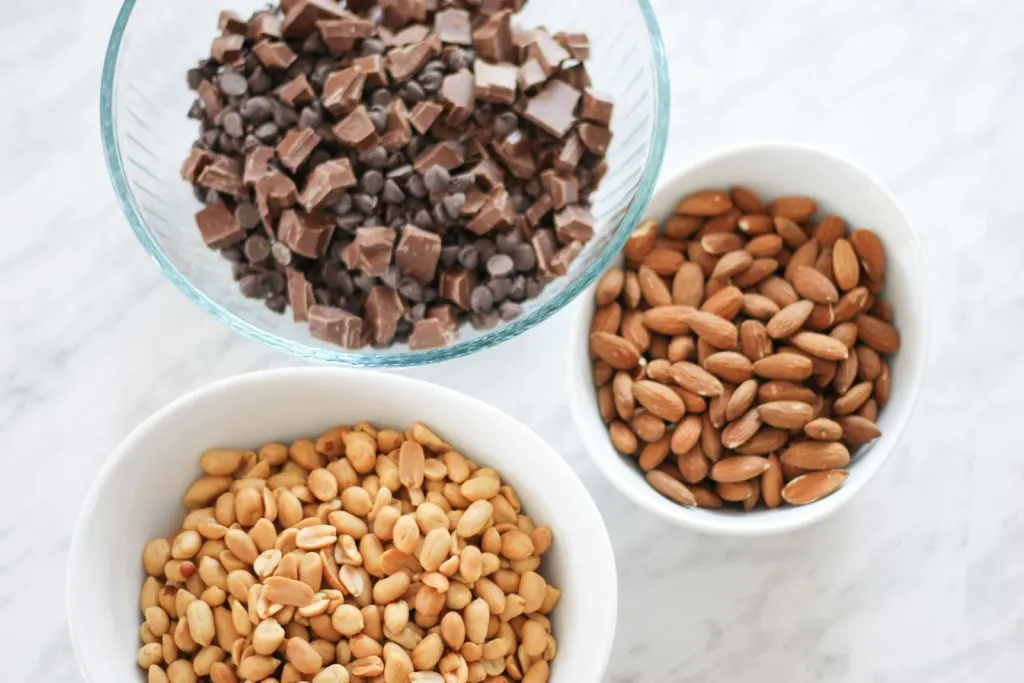 3 bowls on countertop with ingredients for nut clusters. 