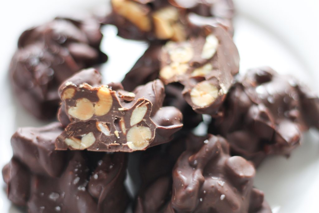 Finished nut clusters on white plate with some cut open to see the inside.